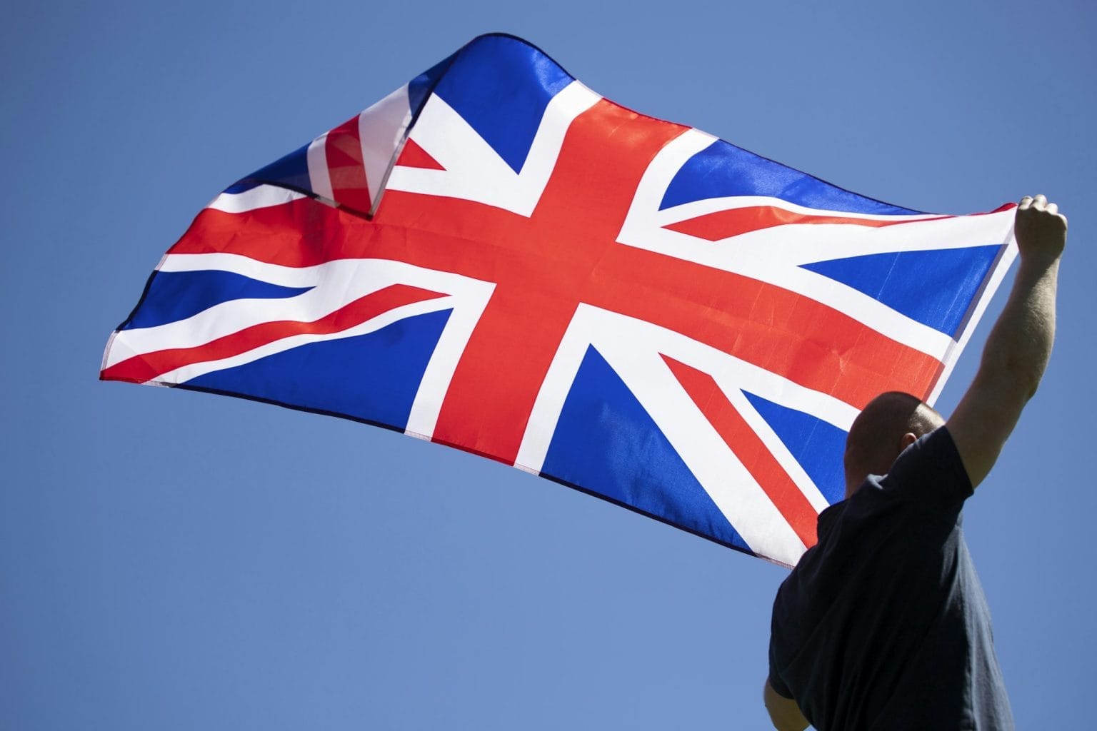 Patriot man holding the United Kingdom flag.