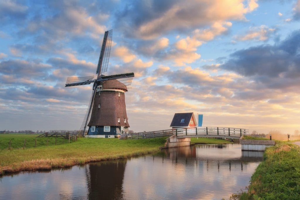 Windmill near the water canal at sunrise in Netherlands